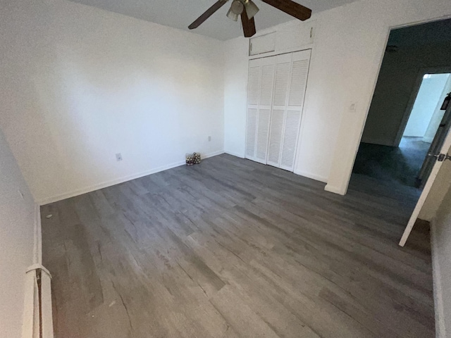 unfurnished bedroom with a closet, dark wood-type flooring, and a ceiling fan