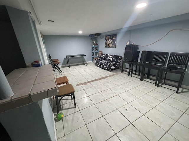 living area featuring light tile patterned floors, baseboards, and recessed lighting