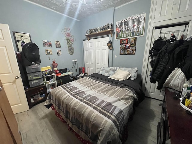 bedroom featuring a closet, light wood-style flooring, and an ornate ceiling