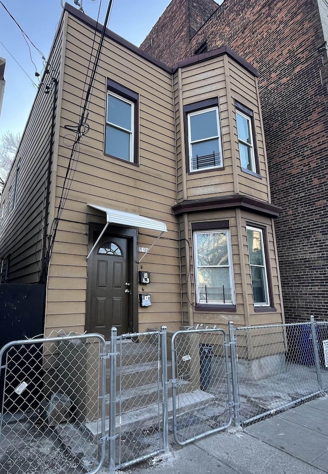 view of front of property with a fenced front yard and a gate