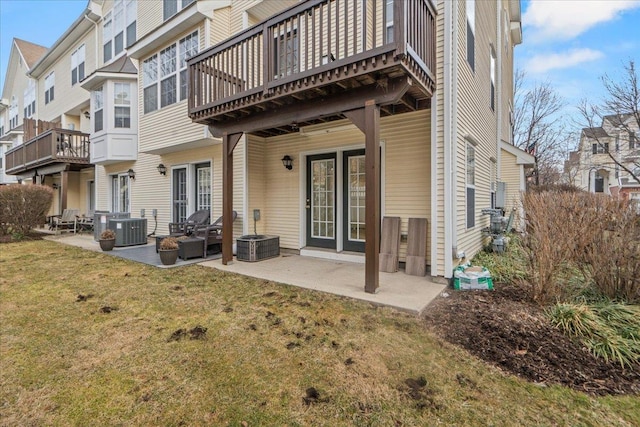 rear view of house featuring cooling unit, a patio, a residential view, and a lawn