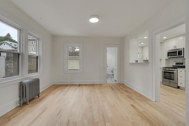 115 Wilson Ave, Rutherford, NJ 07070 - unfurnished living room with radiator heating unit, light wood-type flooring, and baseboards