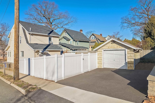 115 Wilson Ave, Rutherford, NJ 07070 - view of side of property featuring asphalt driveway, a detached garage, and a shingled roof