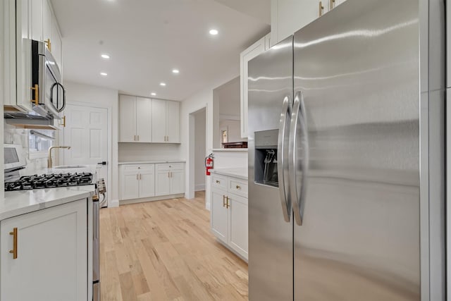 115 Wilson Ave, Rutherford, NJ 07070 - kitchen with stainless steel appliances, white cabinets, light wood finished floors, recessed lighting, and baseboards