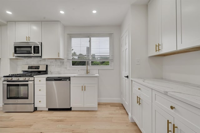 115 Wilson Ave, Rutherford, NJ 07070 - kitchen with appliances with stainless steel finishes, a sink, recessed lighting, white cabinets, and light wood-style flooring