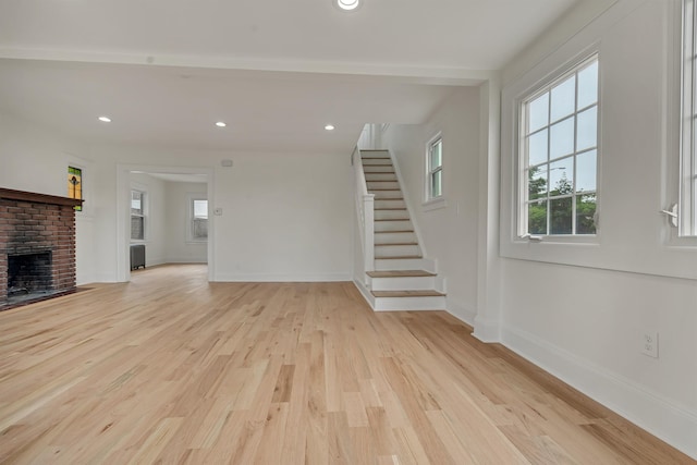 115 Wilson Ave, Rutherford, NJ 07070 - unfurnished living room with light wood finished floors, stairs, baseboards, a brick fireplace, and recessed lighting