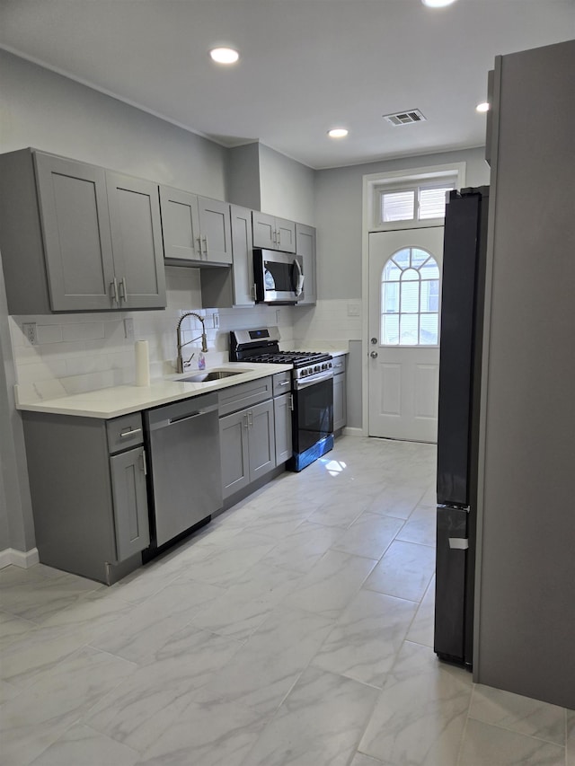 29 48th St, Weehawken, NJ 07086 - kitchen featuring tasteful backsplash, a sink, visible vents, stainless steel appliances, and gray cabinets