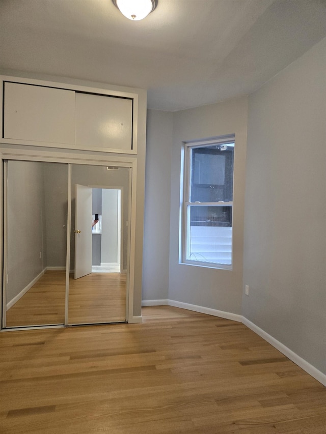 29 48th St, Weehawken, NJ 07086 - unfurnished bedroom with a closet, baseboards, and light wood-style floors