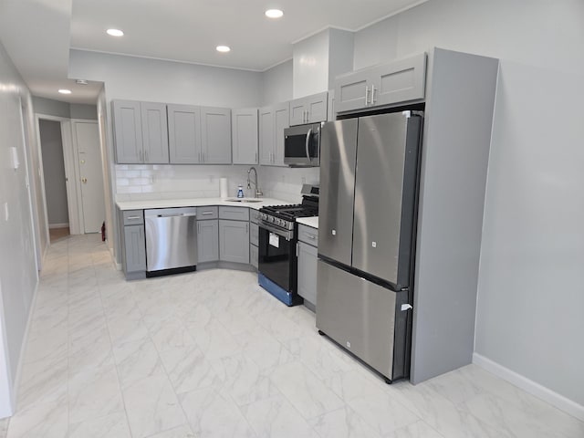 29 48th St, Weehawken, NJ 07086 - kitchen featuring appliances with stainless steel finishes, gray cabinetry, light countertops, baseboards, and marble finish floor