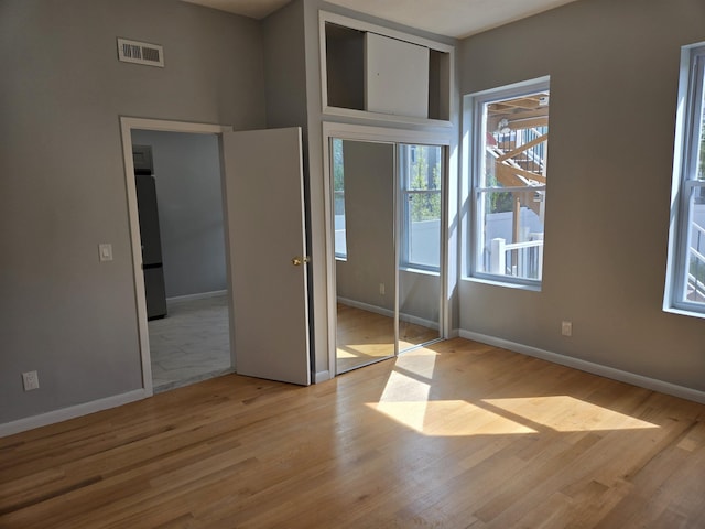 29 48th St, Weehawken, NJ 07086 - unfurnished bedroom with fridge, visible vents, a closet, baseboards, and wood finished floors