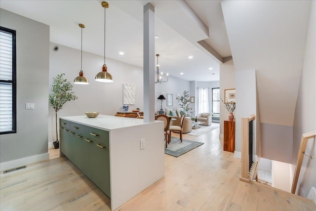 kitchen with an inviting chandelier, light hardwood / wood-style flooring, hanging light fixtures, and green cabinetry