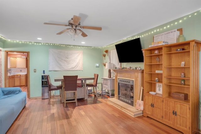 living room featuring light hardwood / wood-style flooring and ceiling fan