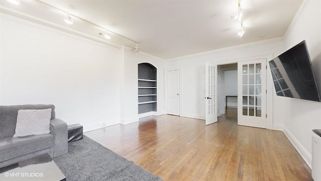 living room featuring french doors, rail lighting, hardwood / wood-style flooring, and ornamental molding