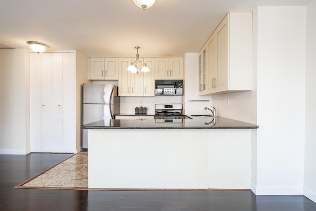 135 Montgomery St Unit 21H, Jersey City, NJ 07302 - kitchen with stainless steel appliances, baseboards, a sink, a peninsula, and glass insert cabinets