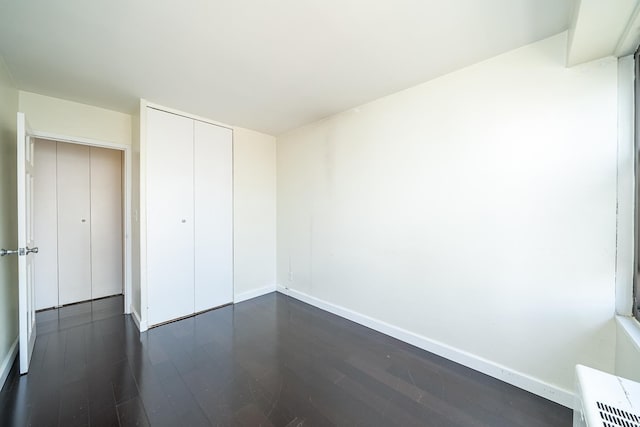 135 Montgomery St Unit 21H, Jersey City, NJ 07302 - unfurnished bedroom featuring dark wood finished floors, baseboards, and a closet