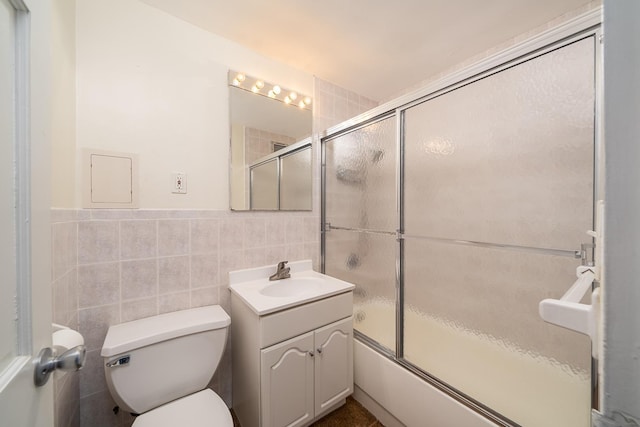 135 Montgomery St Unit 21H, Jersey City, NJ 07302 - full bath featuring vanity, toilet, tile walls, combined bath / shower with glass door, and wainscoting