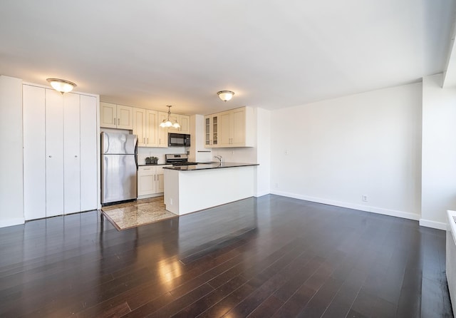 135 Montgomery St Unit 21H, Jersey City, NJ 07302 - kitchen with appliances with stainless steel finishes, dark countertops, a chandelier, glass insert cabinets, and dark wood-style flooring