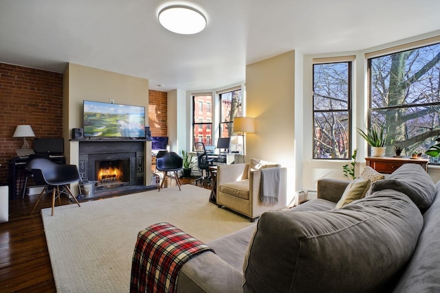 living room with a baseboard radiator, brick wall, and dark wood-type flooring