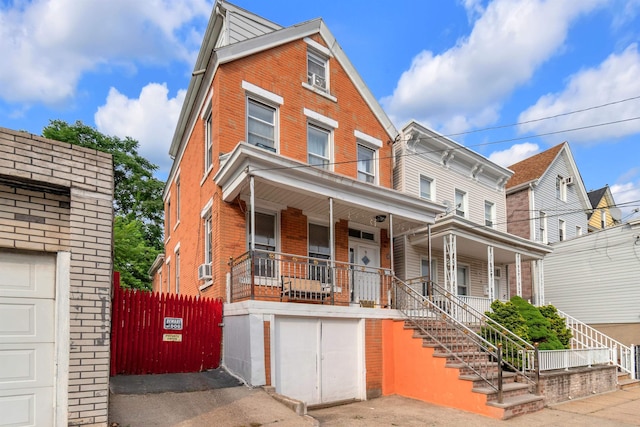 9 E 15th St, Bayonne, NJ 07002 - view of front of house with brick siding, covered porch, stairs, and an attached garage