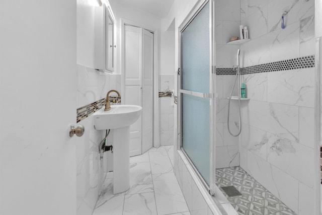 9 E 15th St, Bayonne, NJ 07002 - bathroom with a stall shower, marble look tiles, a wainscoted wall, and tile walls