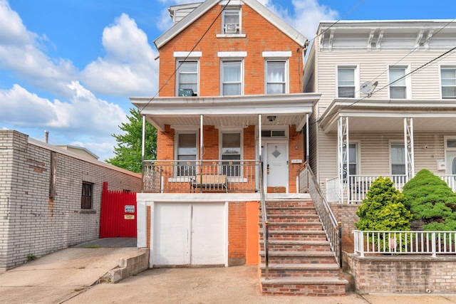 9 E 15th St, Bayonne, NJ 07002 - view of front of home featuring brick siding, a porch, a garage, and stairway