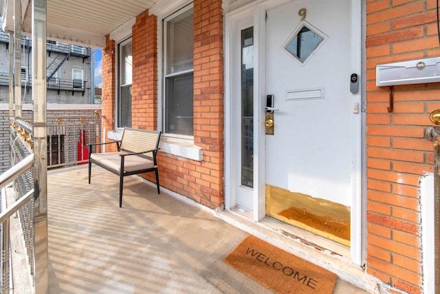 9 E 15th St, Bayonne, NJ 07002 - doorway to property featuring covered porch and brick siding