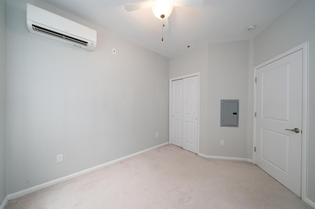 unfurnished bedroom with light carpet, baseboards, an AC wall unit, a closet, and electric panel