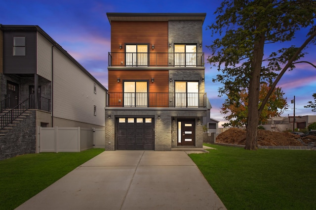 view of front of home featuring a yard, a balcony, and a garage