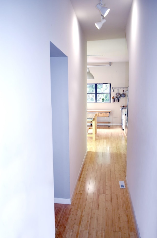 corridor with light hardwood / wood-style flooring