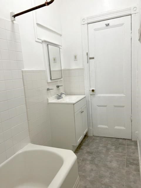 bathroom with vanity and tile walls