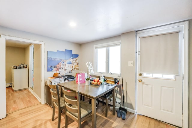 dining space featuring wood-type flooring and a baseboard heating unit