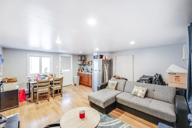 living room with light hardwood / wood-style floors and a baseboard heating unit