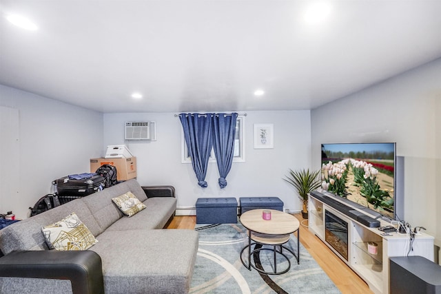 living room featuring light wood-type flooring, baseboard heating, and a wall mounted AC