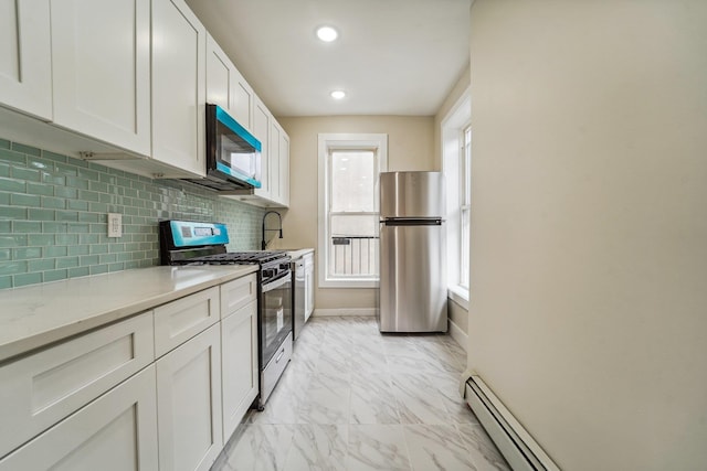 450 1st St Unit 2, Hoboken, NJ 07030 - kitchen featuring appliances with stainless steel finishes, white cabinets, light marble finish flooring, decorative backsplash, and baseboards