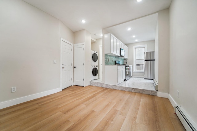 450 1st St Unit 2, Hoboken, NJ 07030 - laundry room with stacked washer and clothes dryer, baseboard heating, light wood-style flooring, baseboards, and recessed lighting