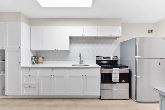 82 E 24th St, Bayonne, NJ 07002 - kitchen with freestanding refrigerator, stainless steel range with electric stovetop, a sink, white cabinetry, and light countertops