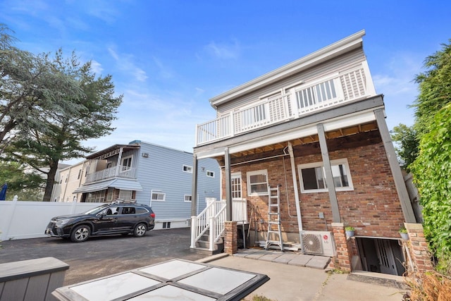 82 E 24th St, Bayonne, NJ 07002 - back of house with a balcony, ac unit, and brick siding