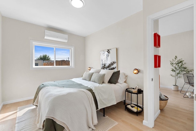 82 E 24th St, Bayonne, NJ 07002 - bedroom featuring a wall mounted air conditioner, light wood-style flooring, and baseboards
