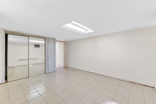 82 E 24th St, Bayonne, NJ 07002 - unfurnished bedroom with a baseboard heating unit, a closet, and light tile patterned floors