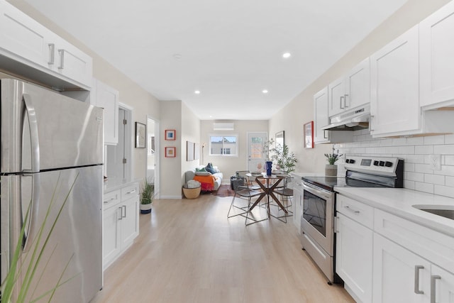 82 E 24th St, Bayonne, NJ 07002 - kitchen featuring appliances with stainless steel finishes, under cabinet range hood, light wood finished floors, white cabinets, and light countertops