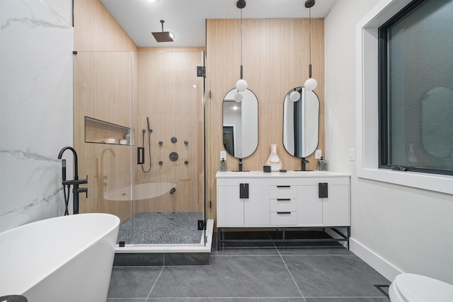 full bath featuring double vanity, a stall shower, tile patterned flooring, a freestanding tub, and a sink