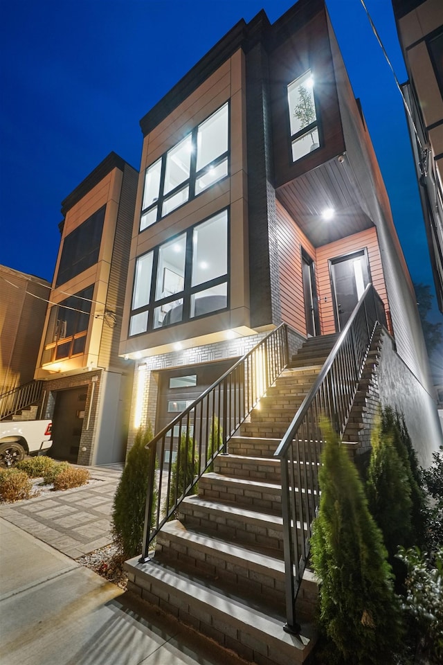 view of front facade with concrete driveway and stairway