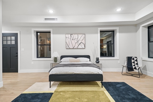 bedroom featuring light wood-type flooring, visible vents, baseboards, and recessed lighting