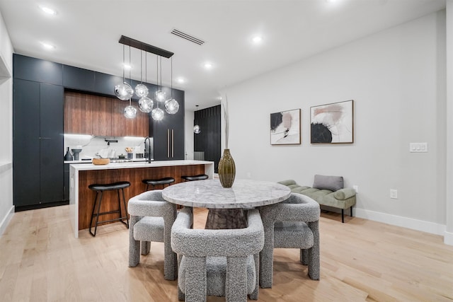 dining room with light wood-type flooring, visible vents, baseboards, and recessed lighting