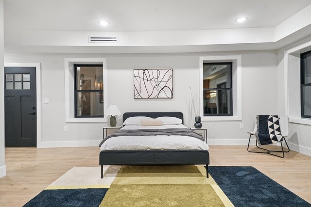 bedroom with light wood-style flooring, recessed lighting, visible vents, and baseboards