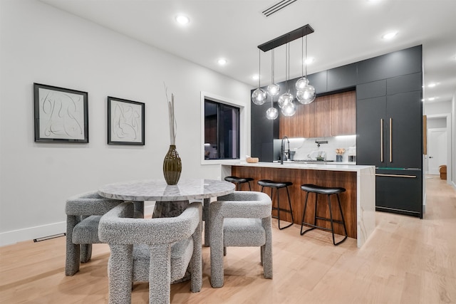 dining area featuring light wood-style floors, baseboards, visible vents, and recessed lighting