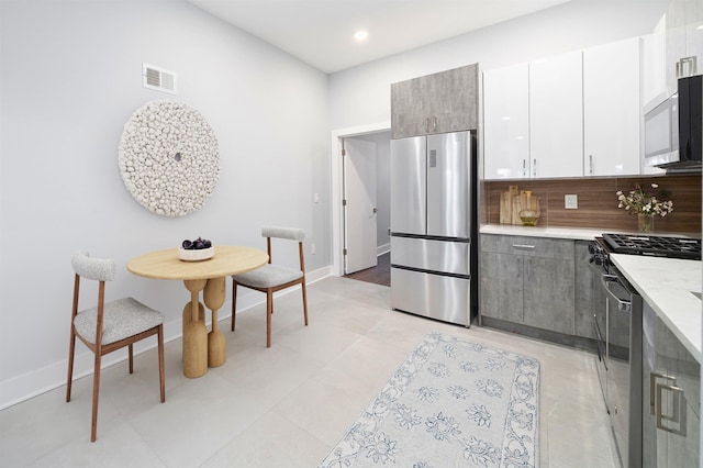 21 Hancock Ave Unit 1, Jersey City, NJ 07307 - kitchen featuring stainless steel appliances, backsplash, recessed lighting, white cabinets, and light tile patterned flooring