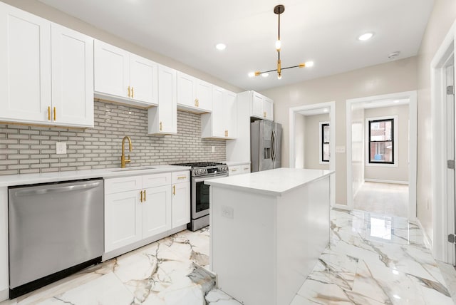 kitchen featuring light countertops, marble finish floor, appliances with stainless steel finishes, and a sink