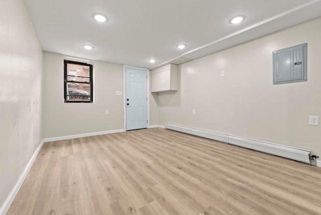 basement with a baseboard heating unit, baseboards, electric panel, recessed lighting, and light wood-style floors