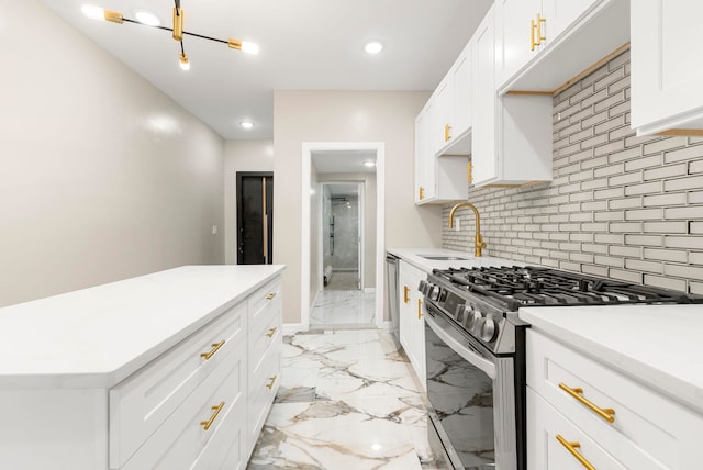 kitchen with a sink, light countertops, appliances with stainless steel finishes, tasteful backsplash, and marble finish floor